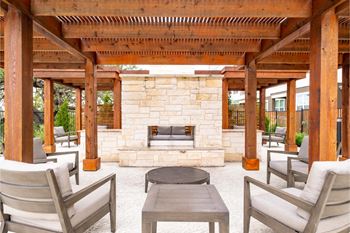 a covered patio with a fireplace at Reveal at Onion Creek apartments